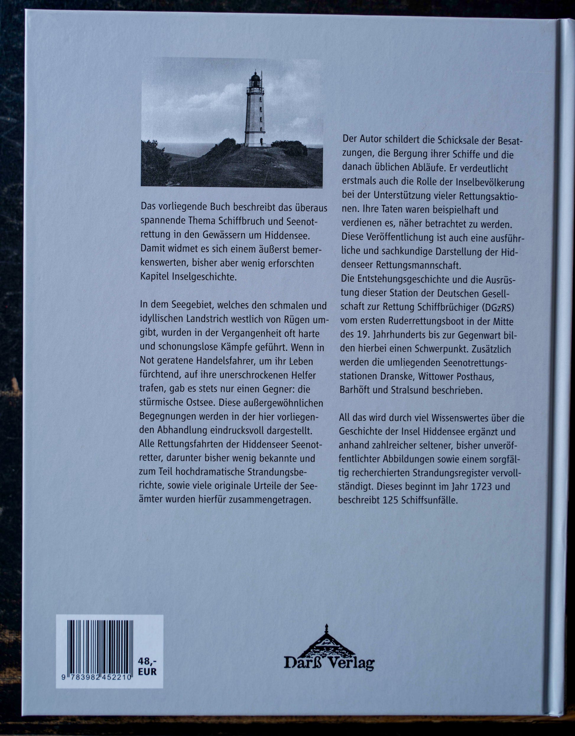 Rückseite des Buchs „Notflagge vor Hiddensee“ von Bernd Goltings, mit Beschreibung zum Thema Schiffbruch und Seenotrettung, Schwarz-Weiß-Foto des Leuchtturms Dornbusch, Darß Verlag.